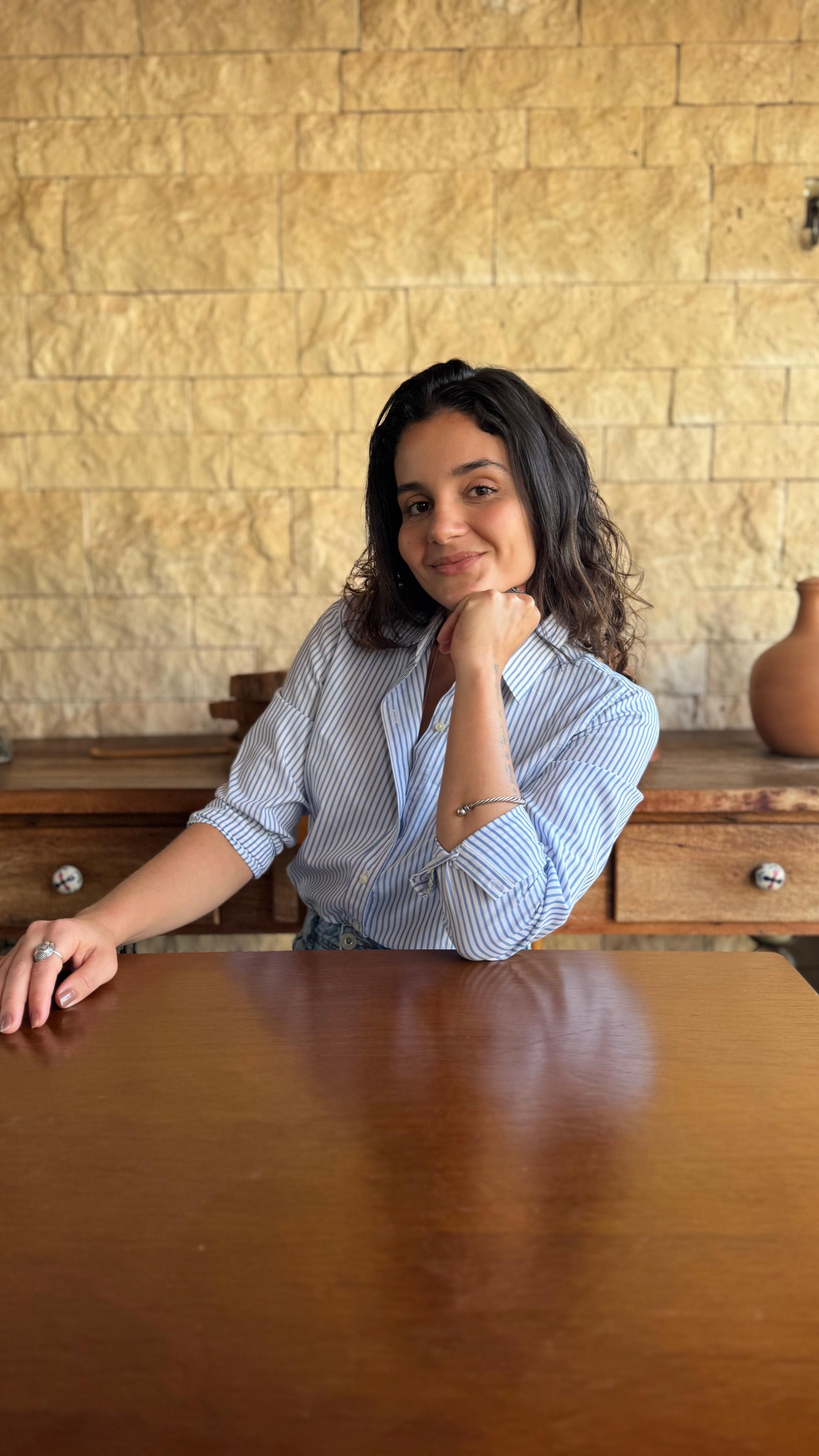 Beatriz Machado sentada à mesa, sorrindo
